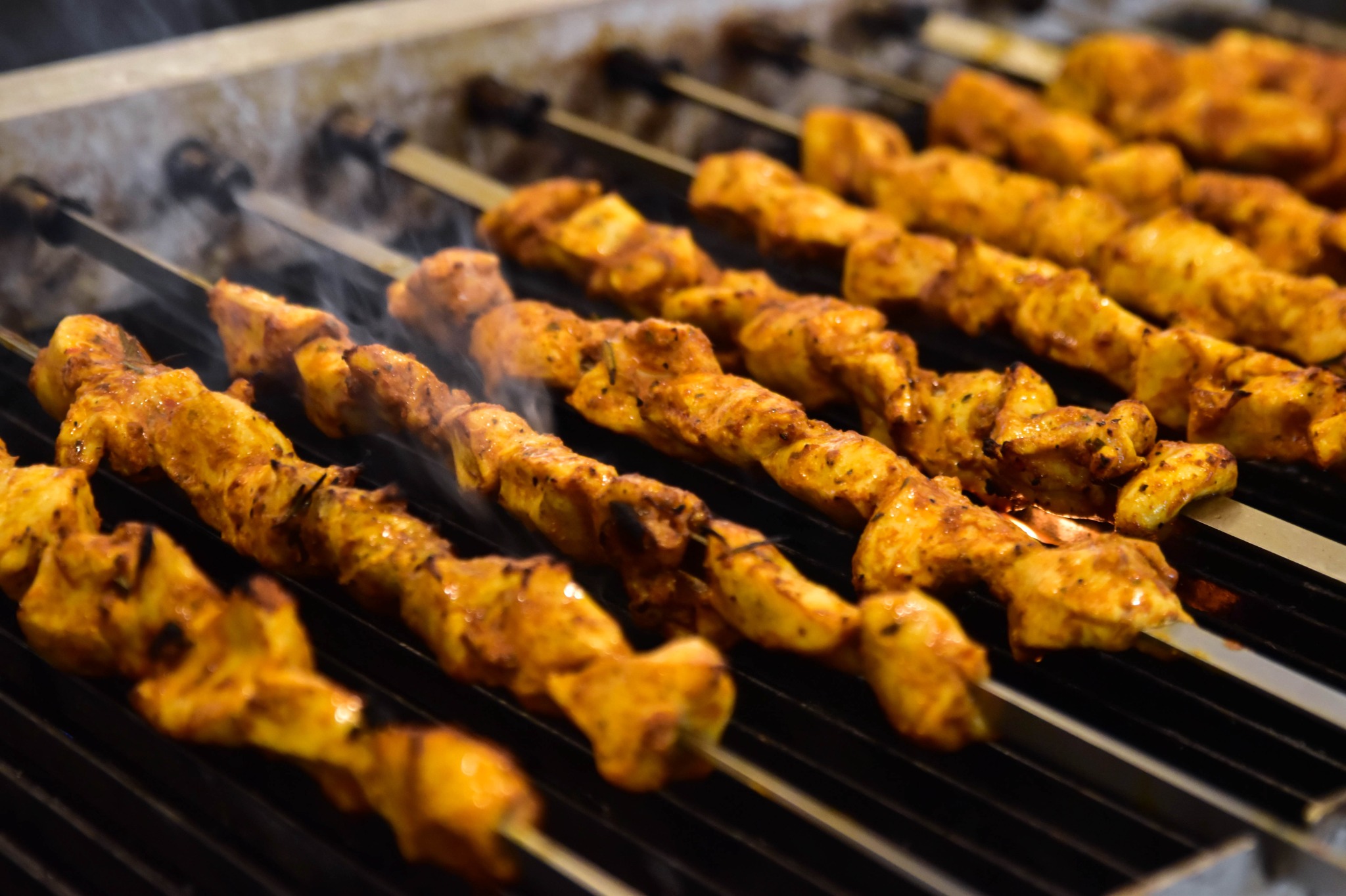 Marinated chicken skewers cooking on the grill